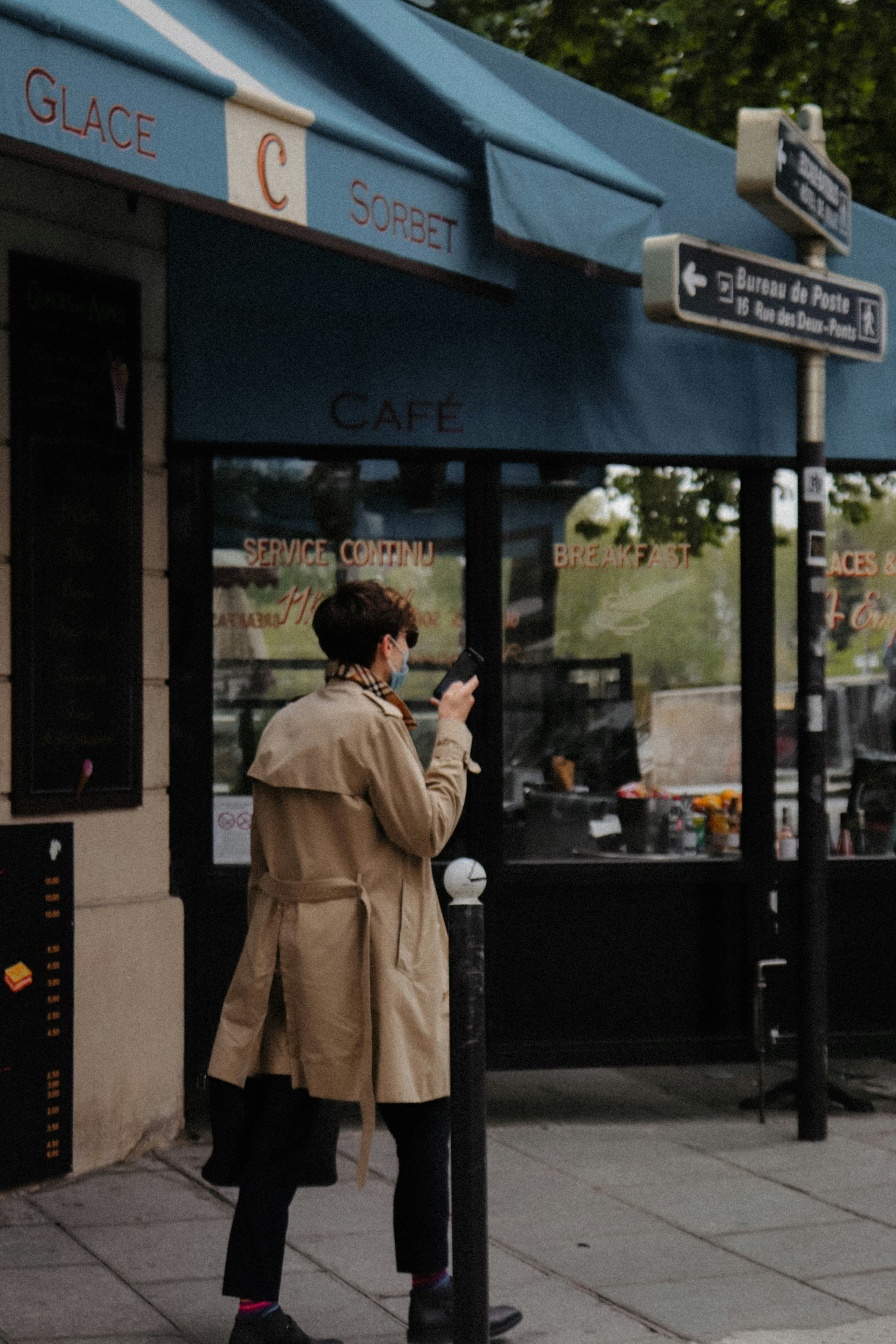 a woman standing on a sidewalk using a cell phone