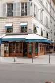 a building with a blue awning next to a street
