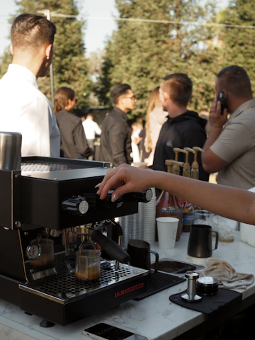 a group of people standing around a coffee machine
