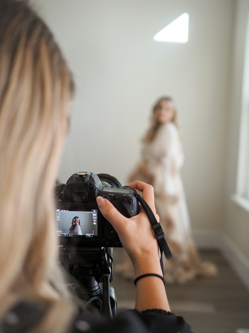 a woman taking a picture of a woman in a wedding dress