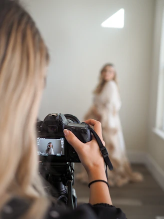 a woman taking a picture of a woman in a wedding dress