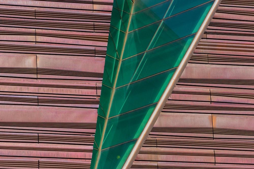 a green airplane is flying over a building