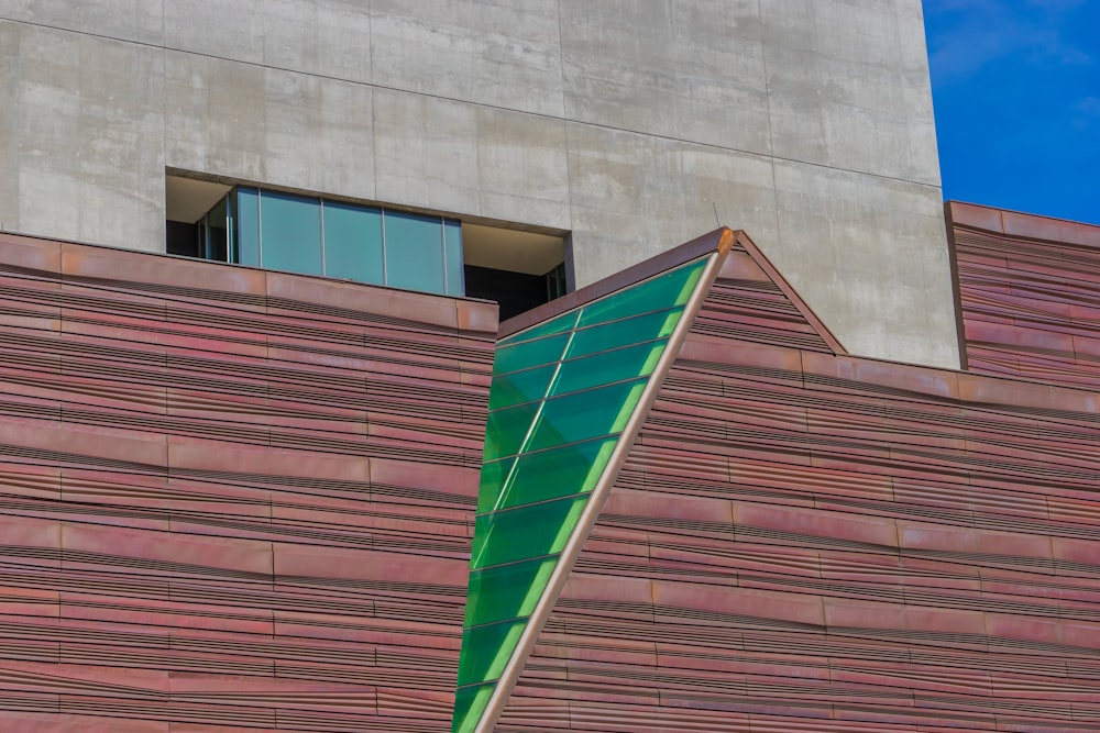 a tall building with a green roof next to a tall building