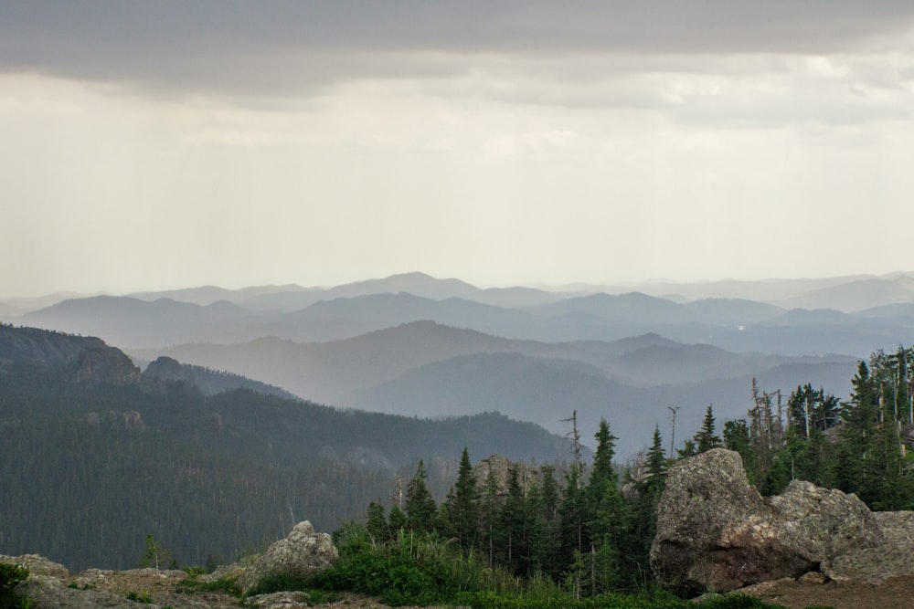 a view of a mountain range with trees and mountains in the background