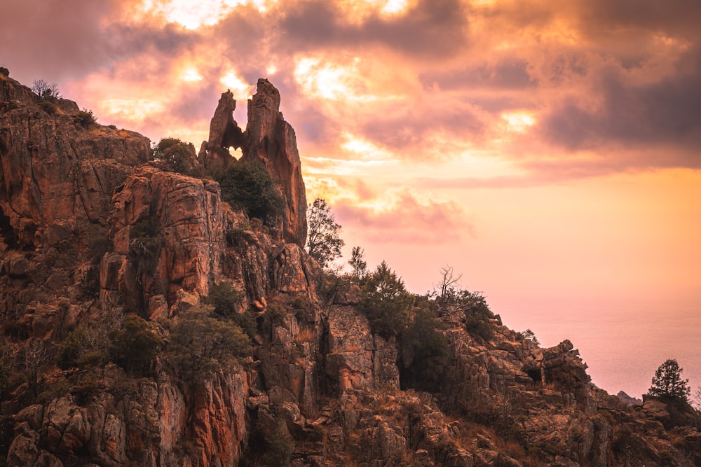 a rocky mountain with trees on top of it