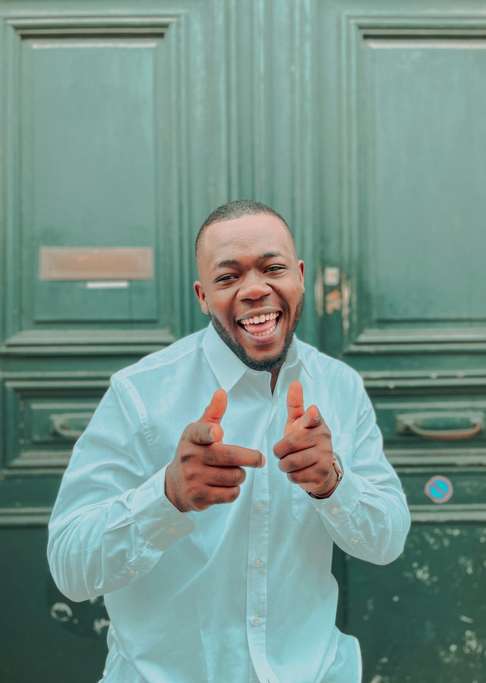 a man in a white shirt is giving a thumbs up