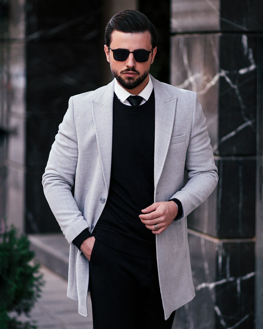 a man in a suit and tie standing on a sidewalk