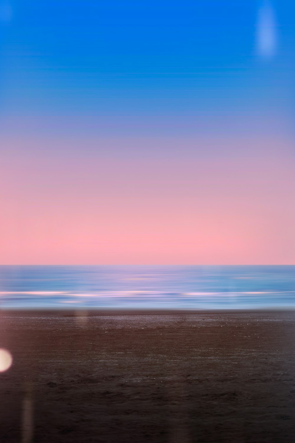 a blurry photo of a beach with the ocean in the background