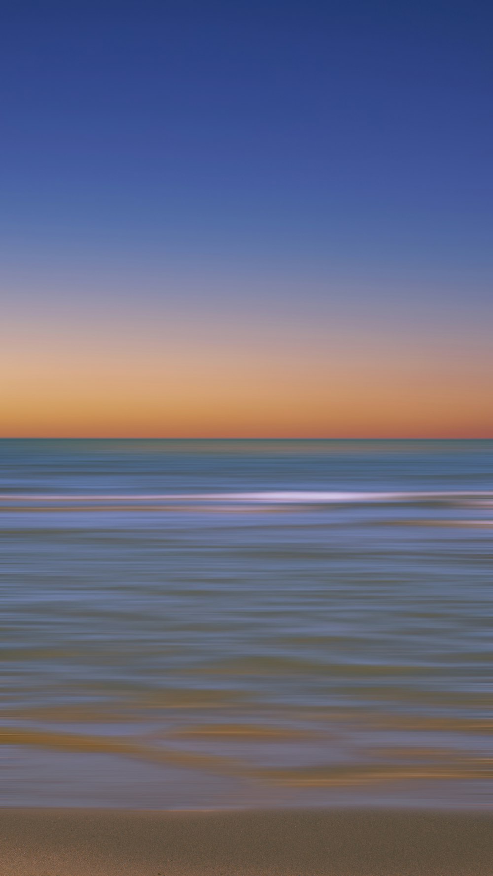 a blurry photo of the ocean at sunset