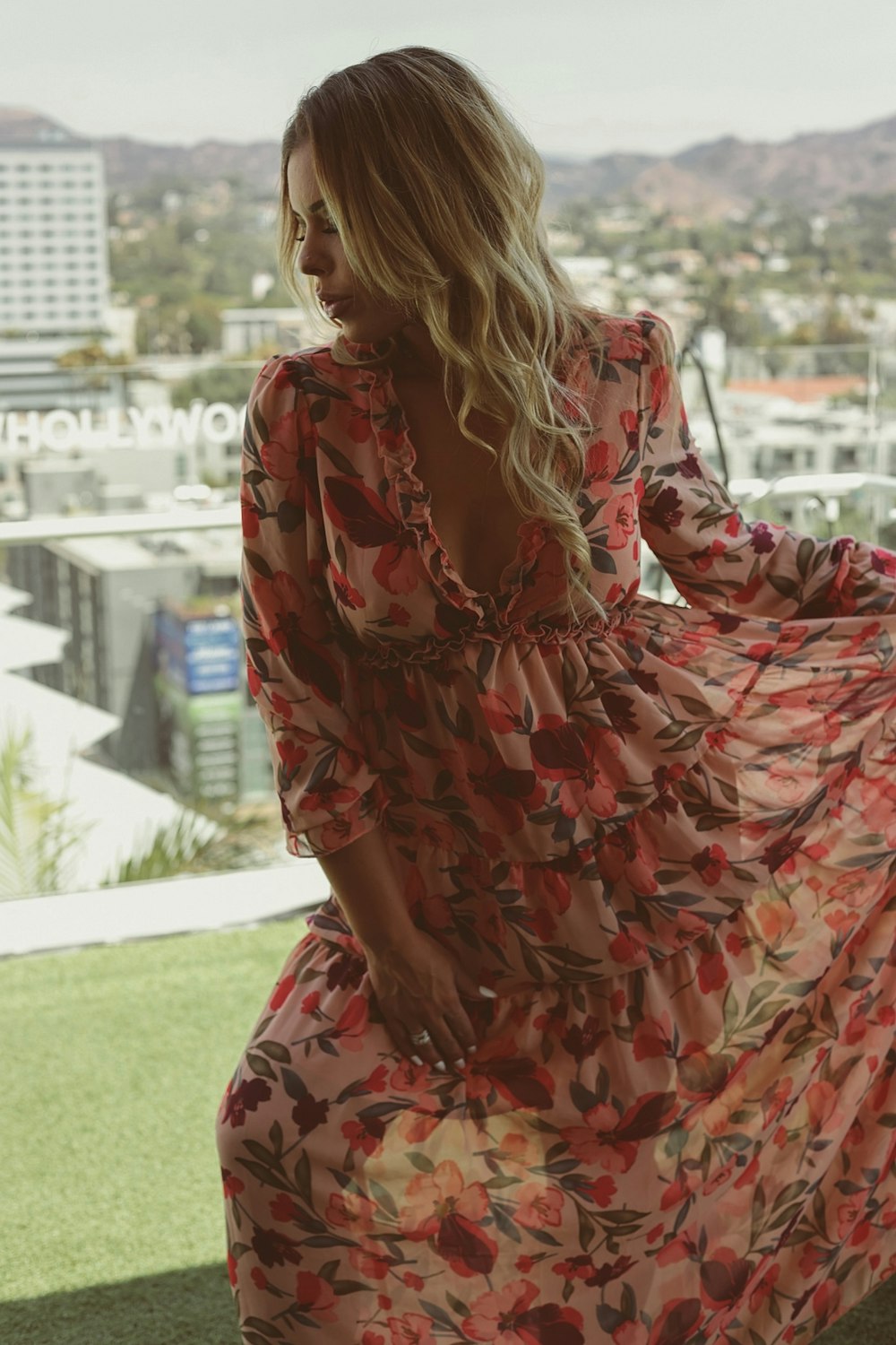 a woman in a long dress standing on a balcony