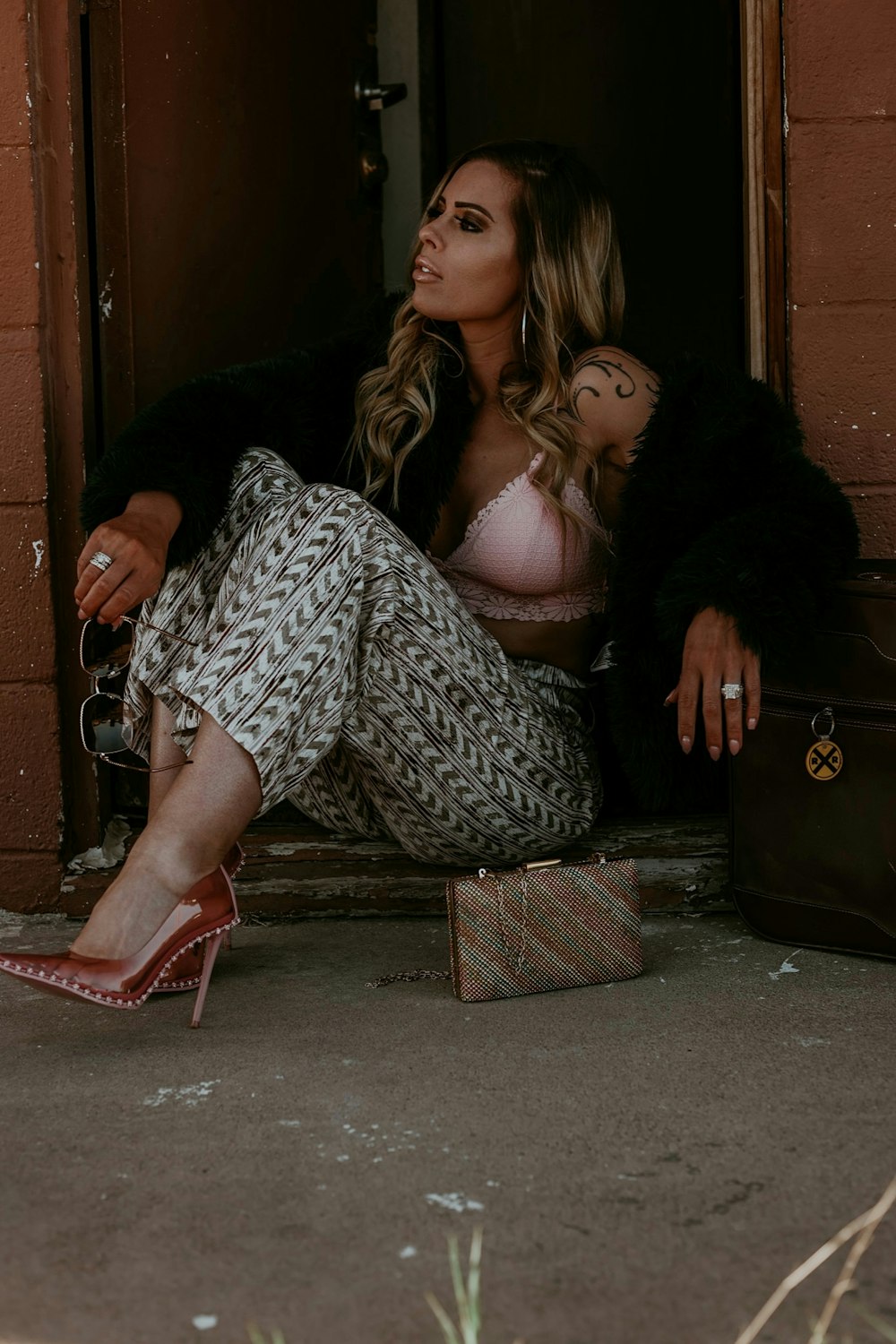 a woman sitting on the ground next to a suitcase