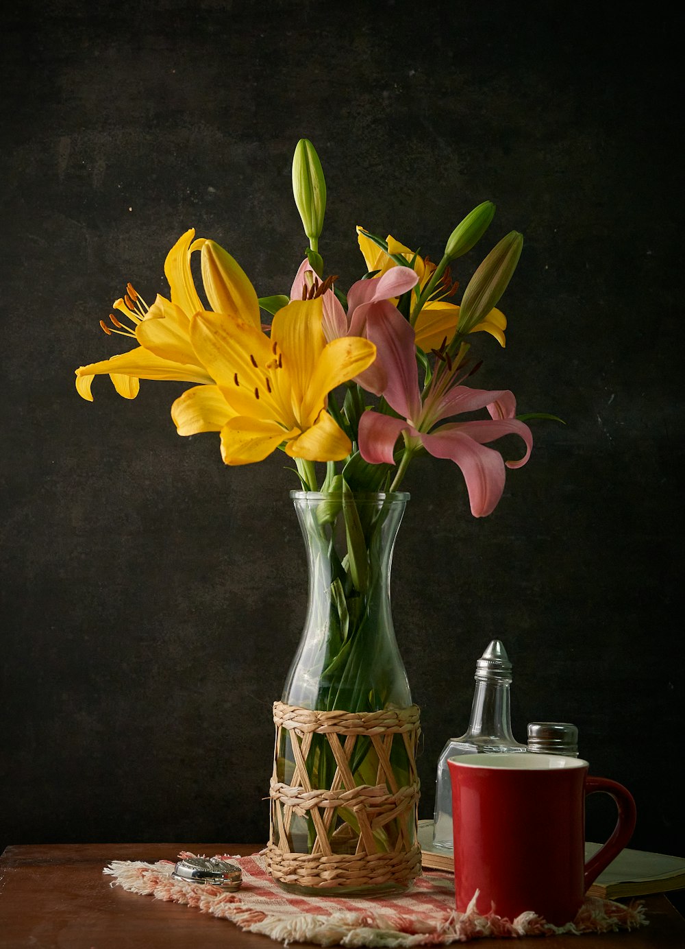 a vase with yellow and pink flowers on a table