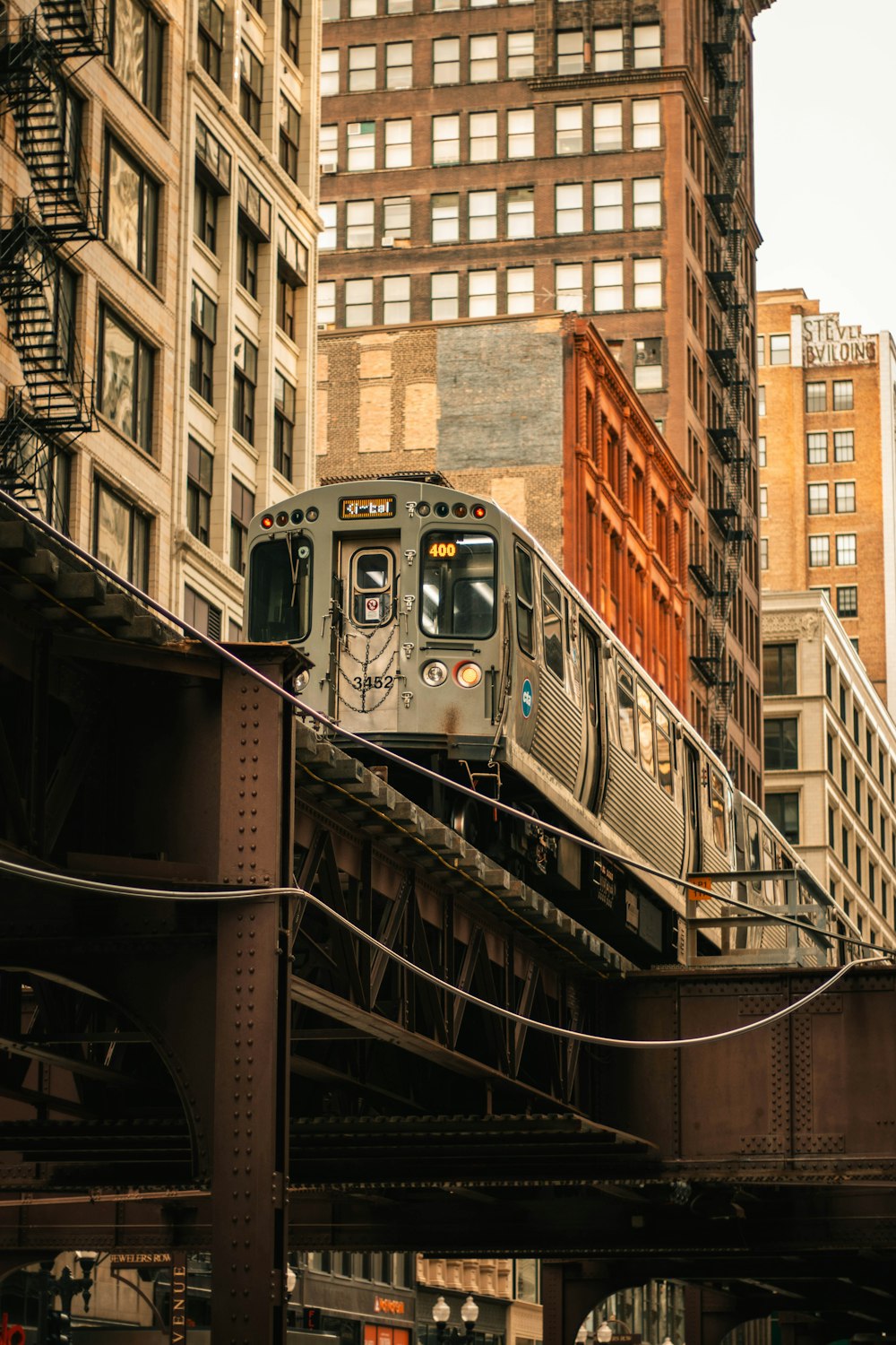 a train traveling over a bridge next to tall buildings