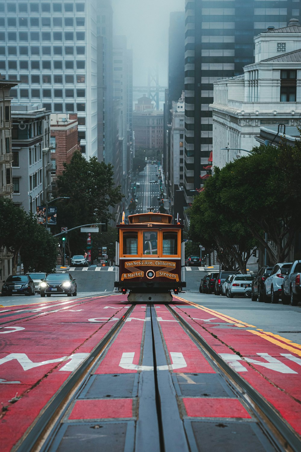 a trolley car traveling down a street next to tall buildings