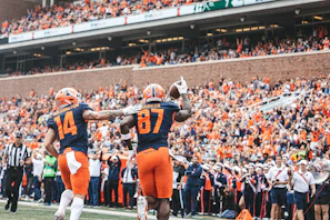 Group of friends celebrating a touchdown with smiles and high-fives