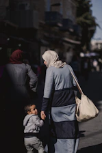 a woman and child walking down a street