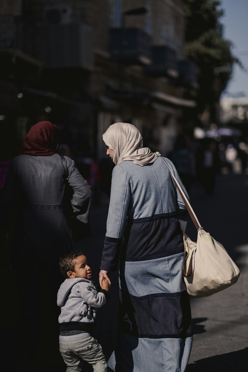 Una donna e un bambino che camminano lungo una strada