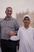 a man standing next to a little boy