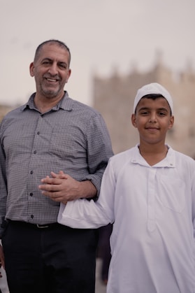 a man standing next to a little boy