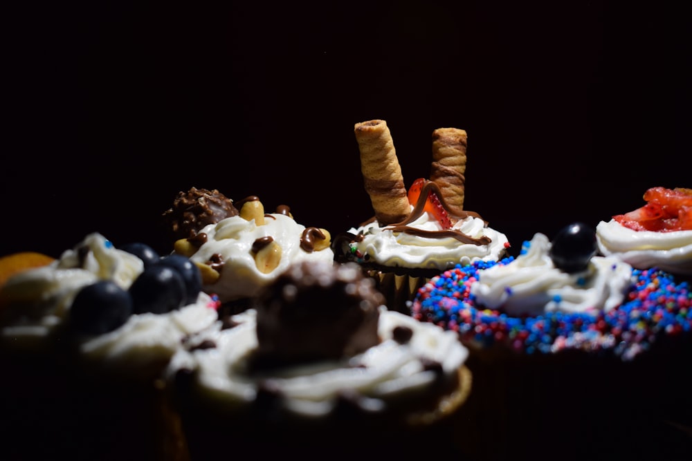 a close up of cupcakes with frosting and toppings