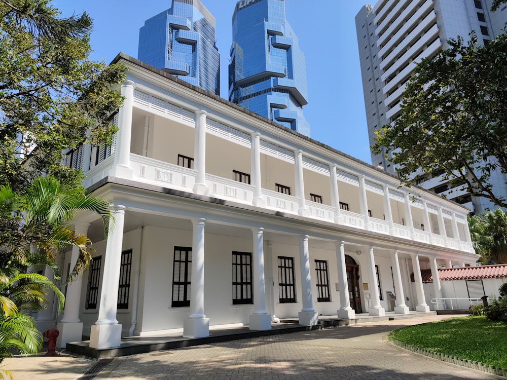 a large white building with two tall buildings in the background