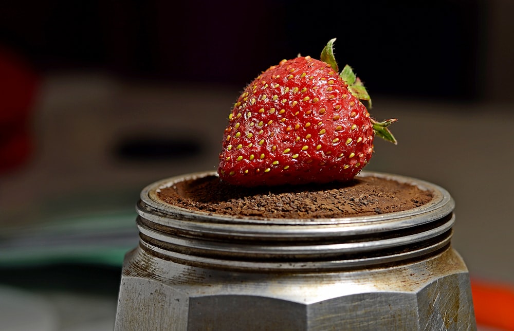 a strawberry sitting on top of a chocolate cake