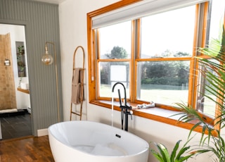 a large white bath tub sitting on top of a wooden floor