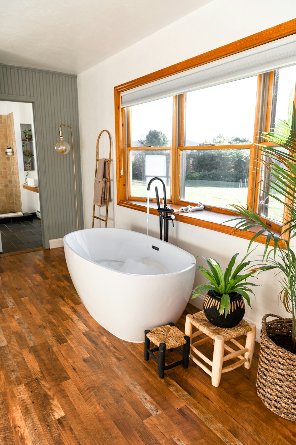 a large white bath tub sitting on top of a wooden floor