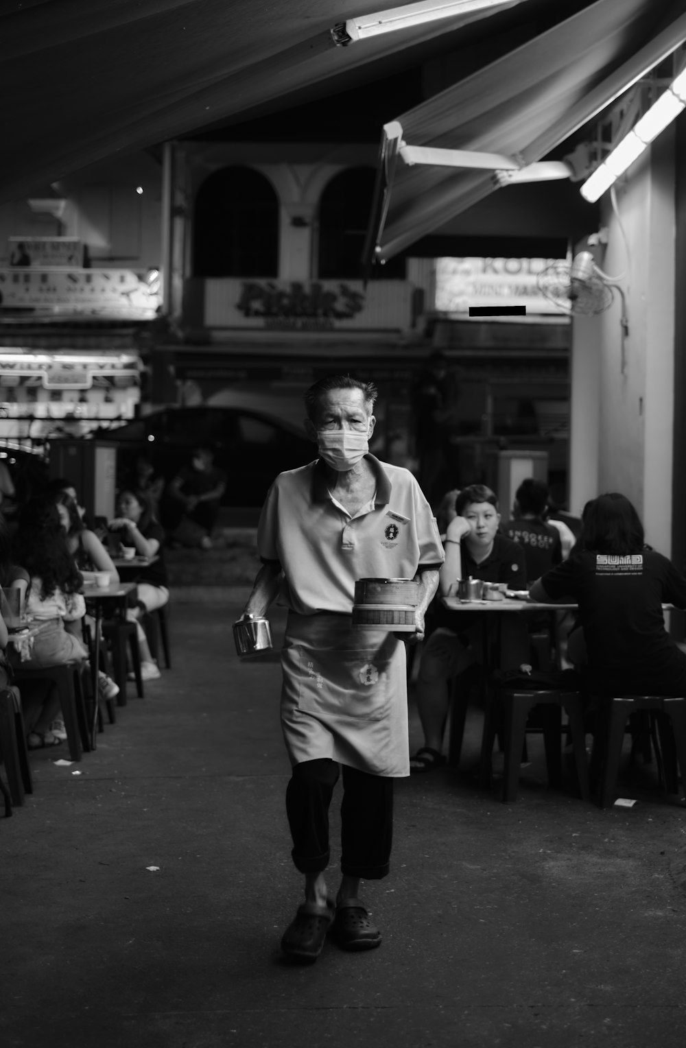 a man walking down a street past a crowd of people