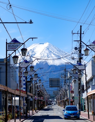 a car driving down a street with a mountain in the background