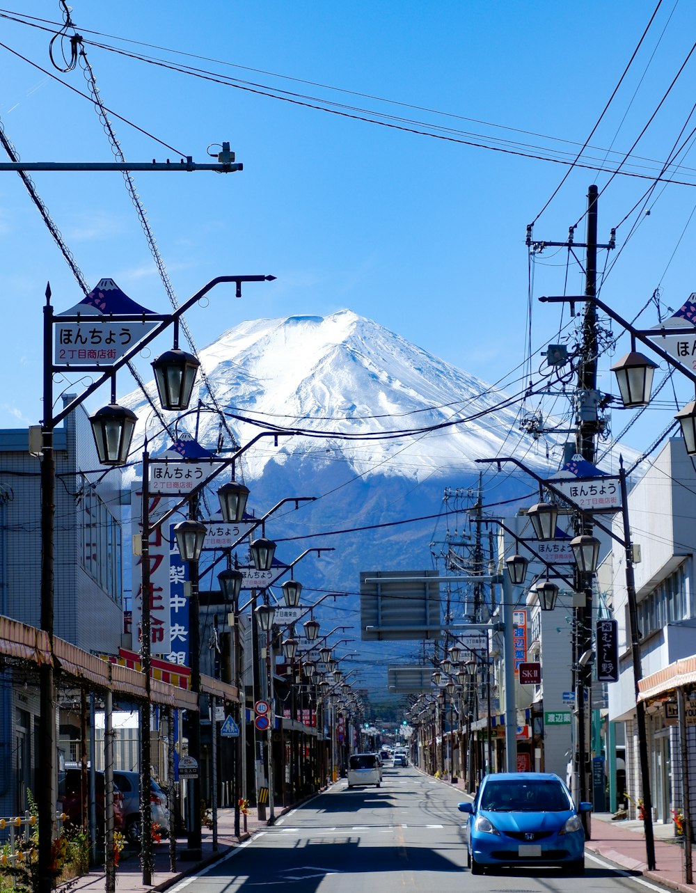 a car driving down a street with a mountain in the background