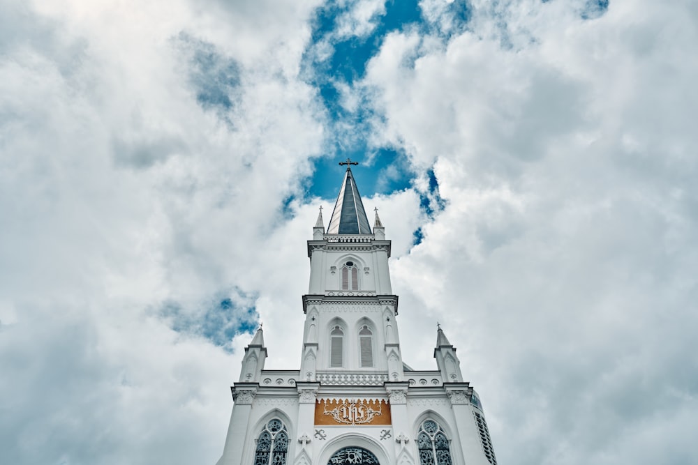 una gran iglesia blanca con un campanario y una cruz en la parte superior