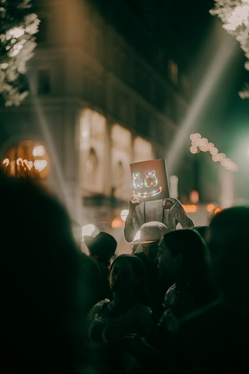 a crowd of people standing around a building at night