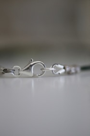 Before and after images of a repaired necklace clasp shining like new.