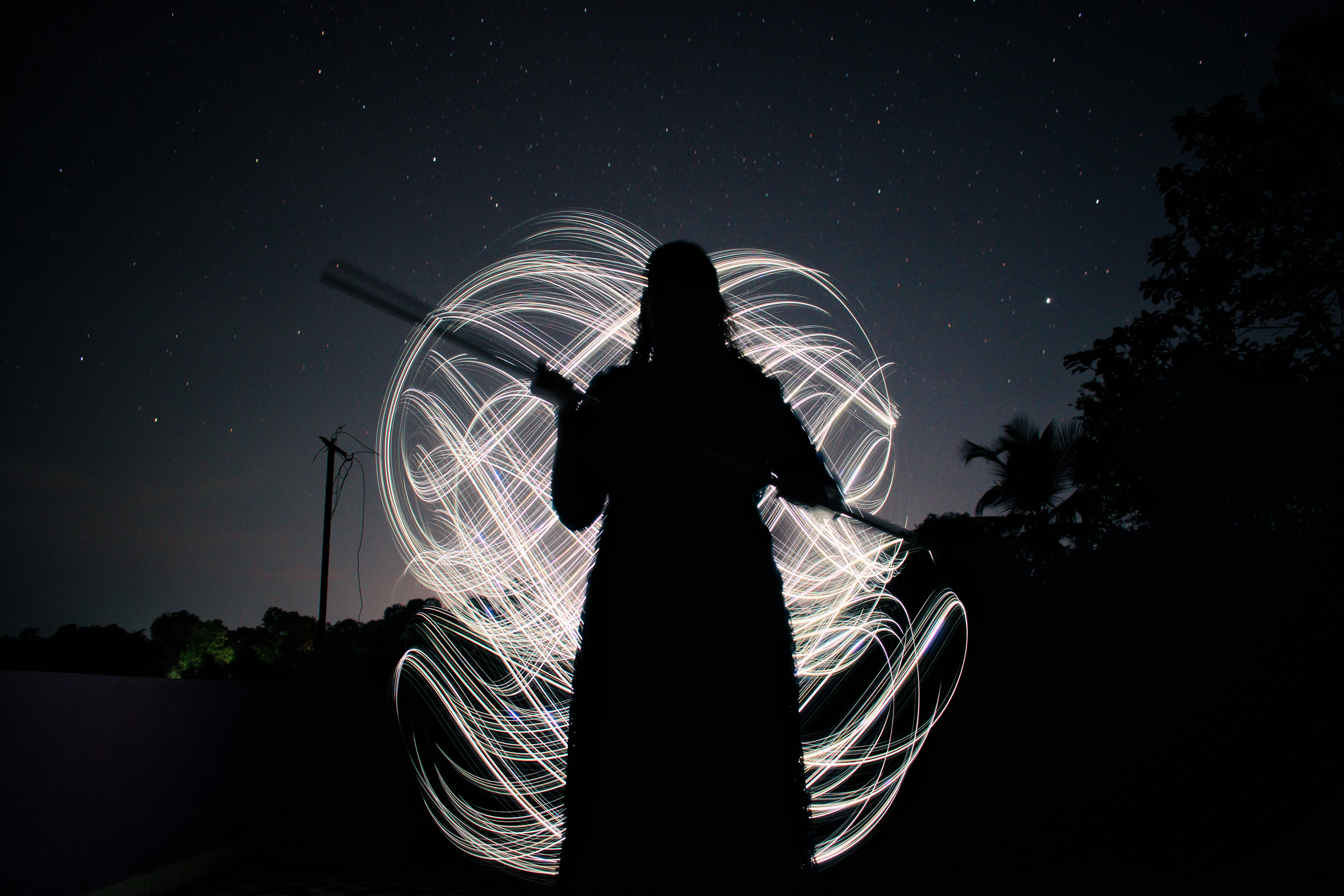 a woman standing in the dark holding a wand