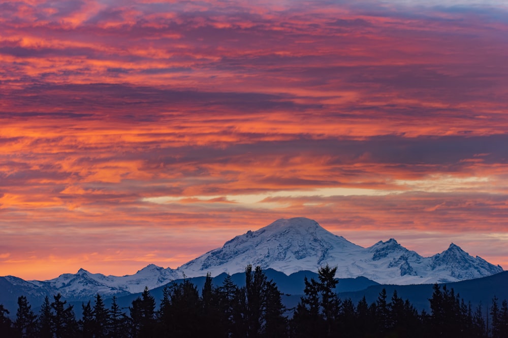 Un cielo rojo y rosa con una montaña al fondo