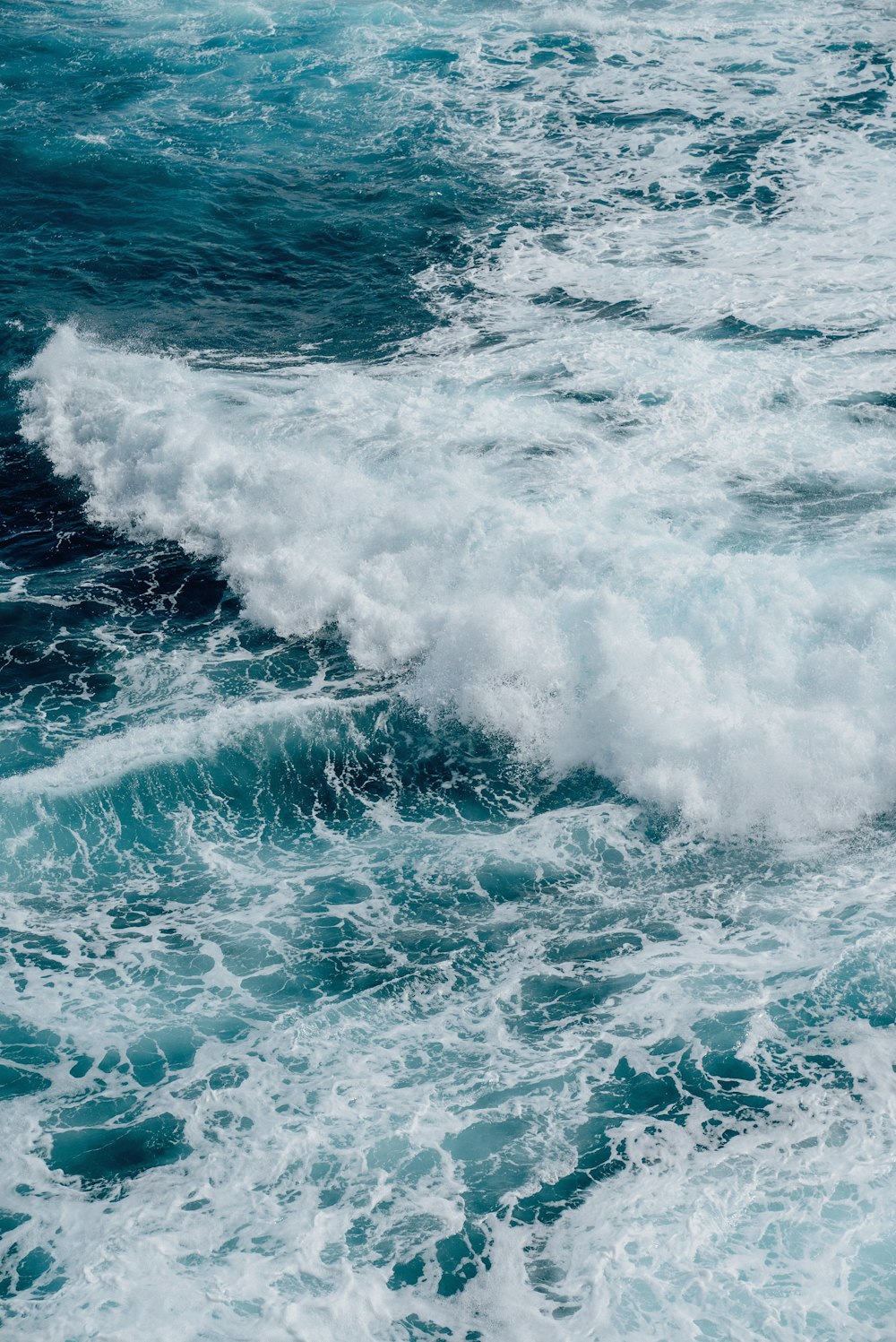 a man riding a surfboard on top of a wave in the ocean