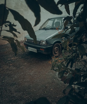 A vintage saloon car with subtle wear, captured in a quiet UK village lane.