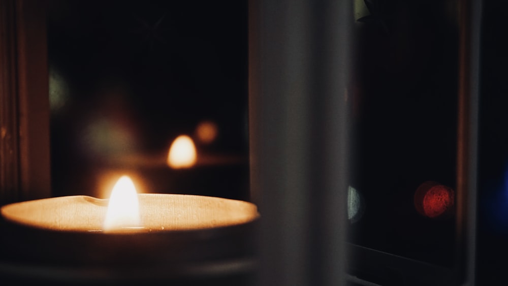 a lit candle sitting on top of a table