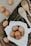 Close-up photo of fresh brown eggs in a rustic basket on a wooden table.