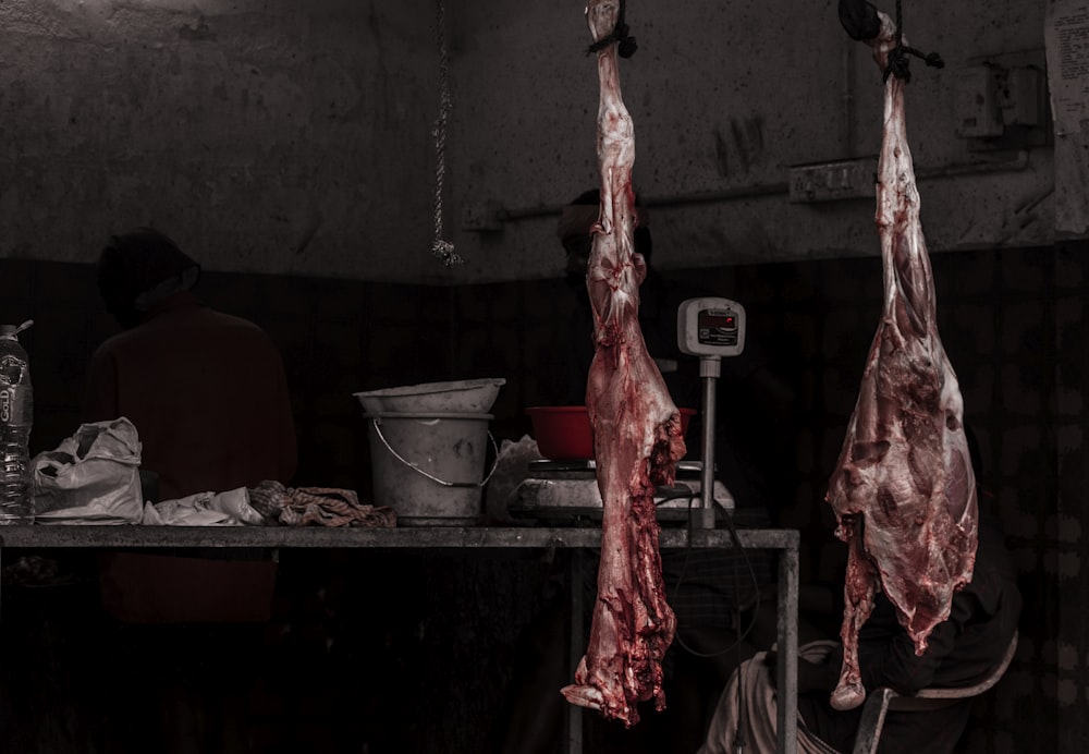 Ein paar Fleisch, die in einer Küche an Haken hängen