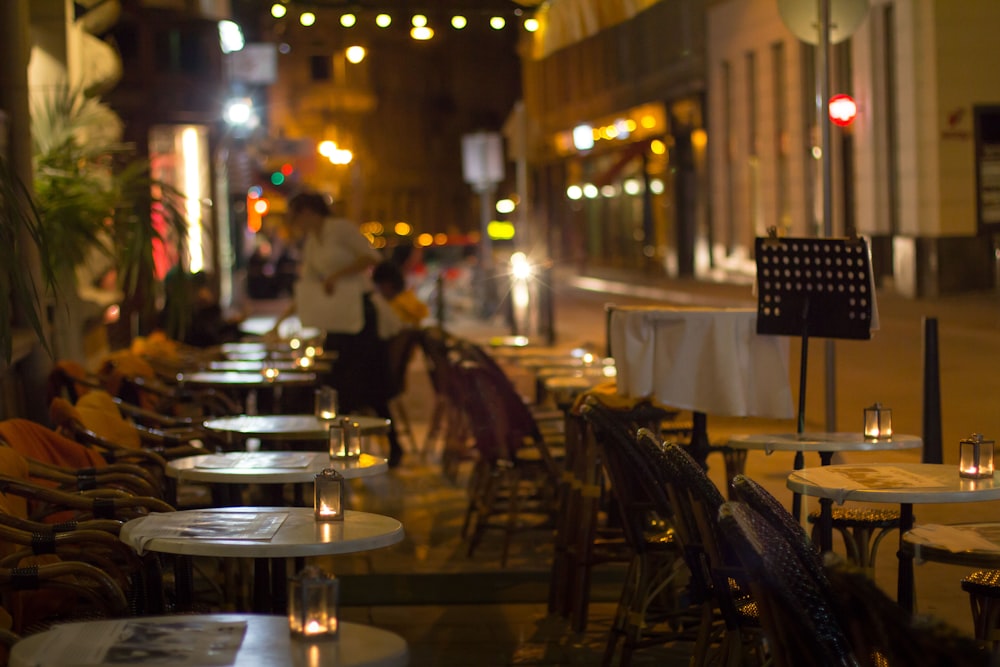 Una fila de mesas sentadas al costado de una calle