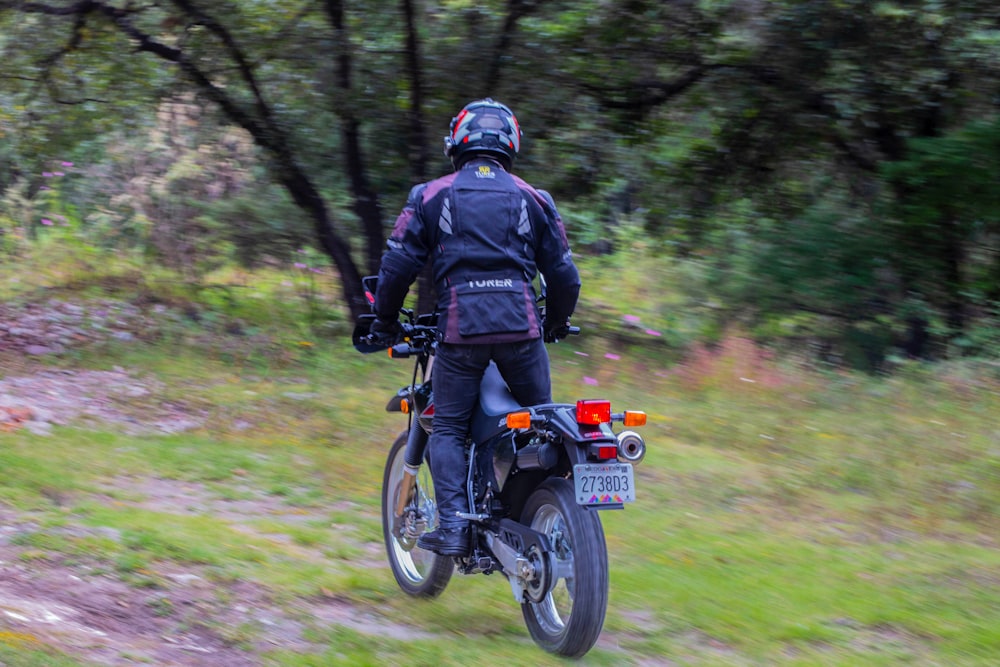 a man riding a motorcycle down a dirt road