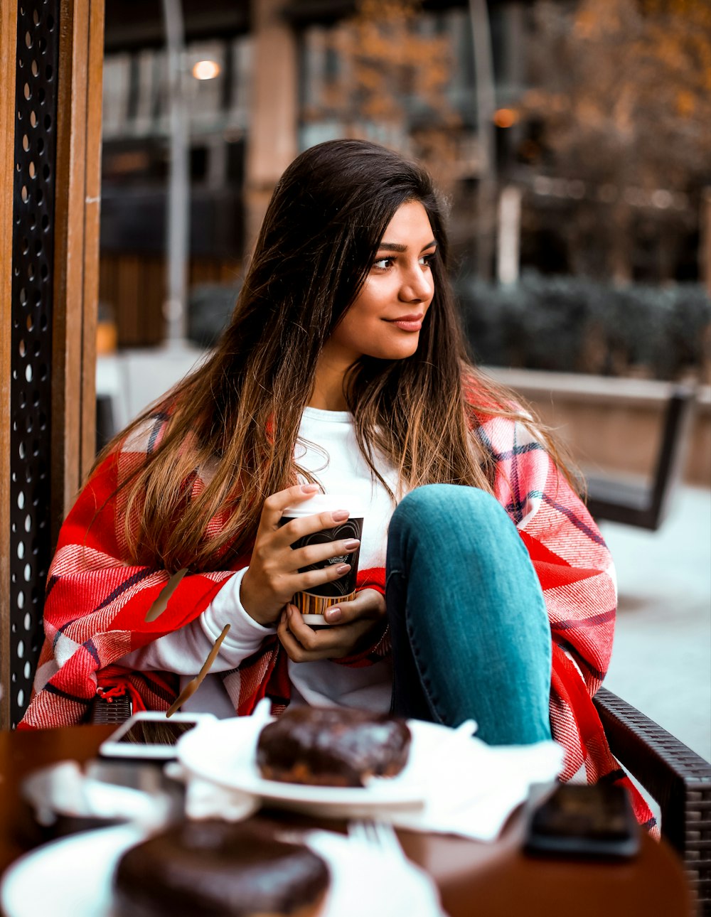 a woman sitting on a bench looking at her cell phone