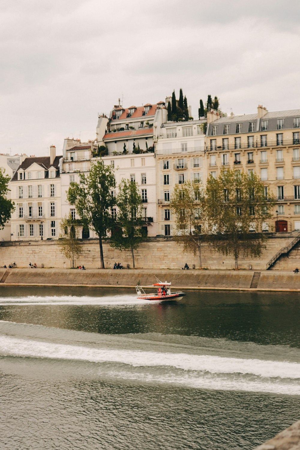 a boat traveling down a river next to tall buildings