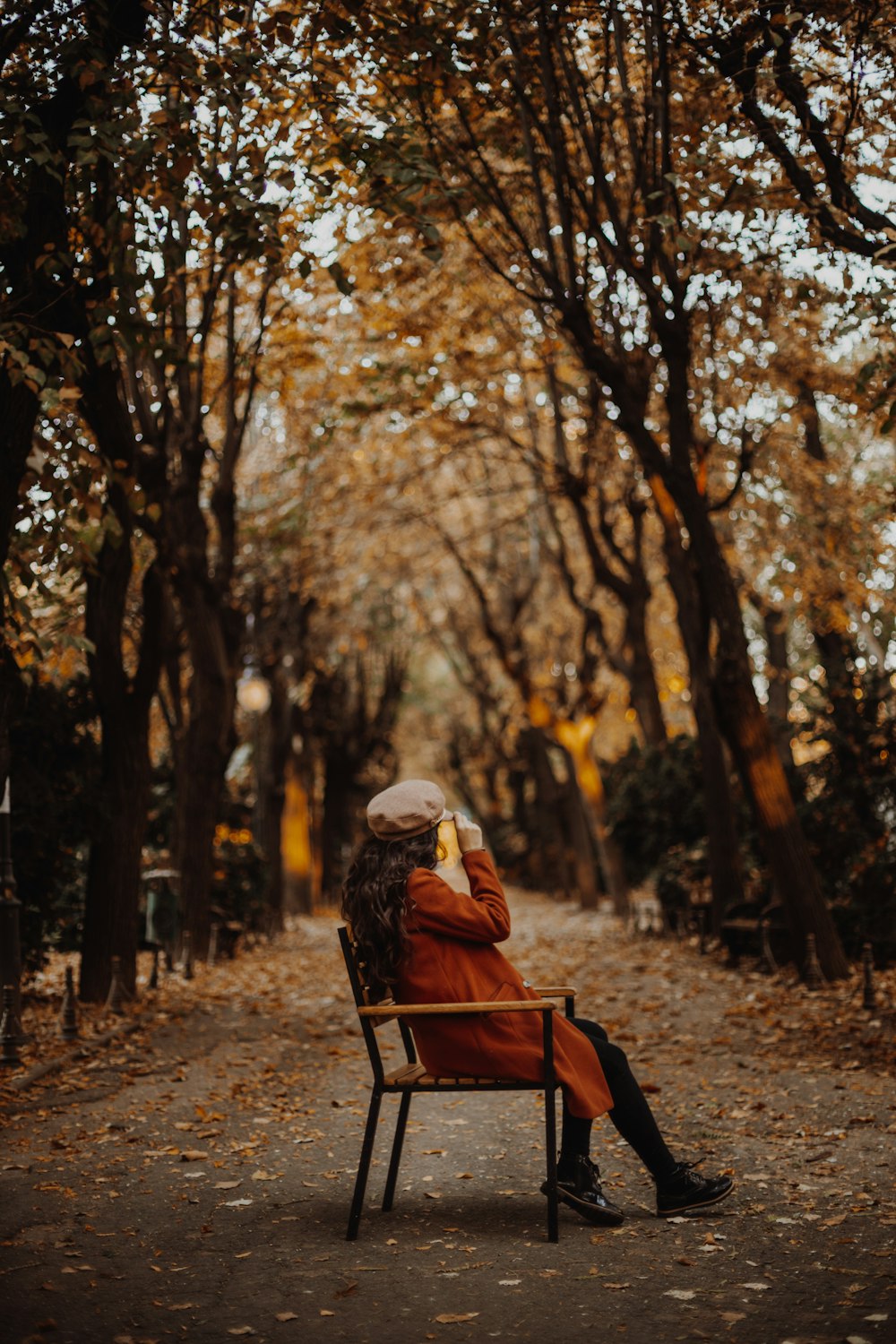a woman sitting on a chair in a park
