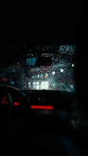 a car dashboard with rain on the windshield