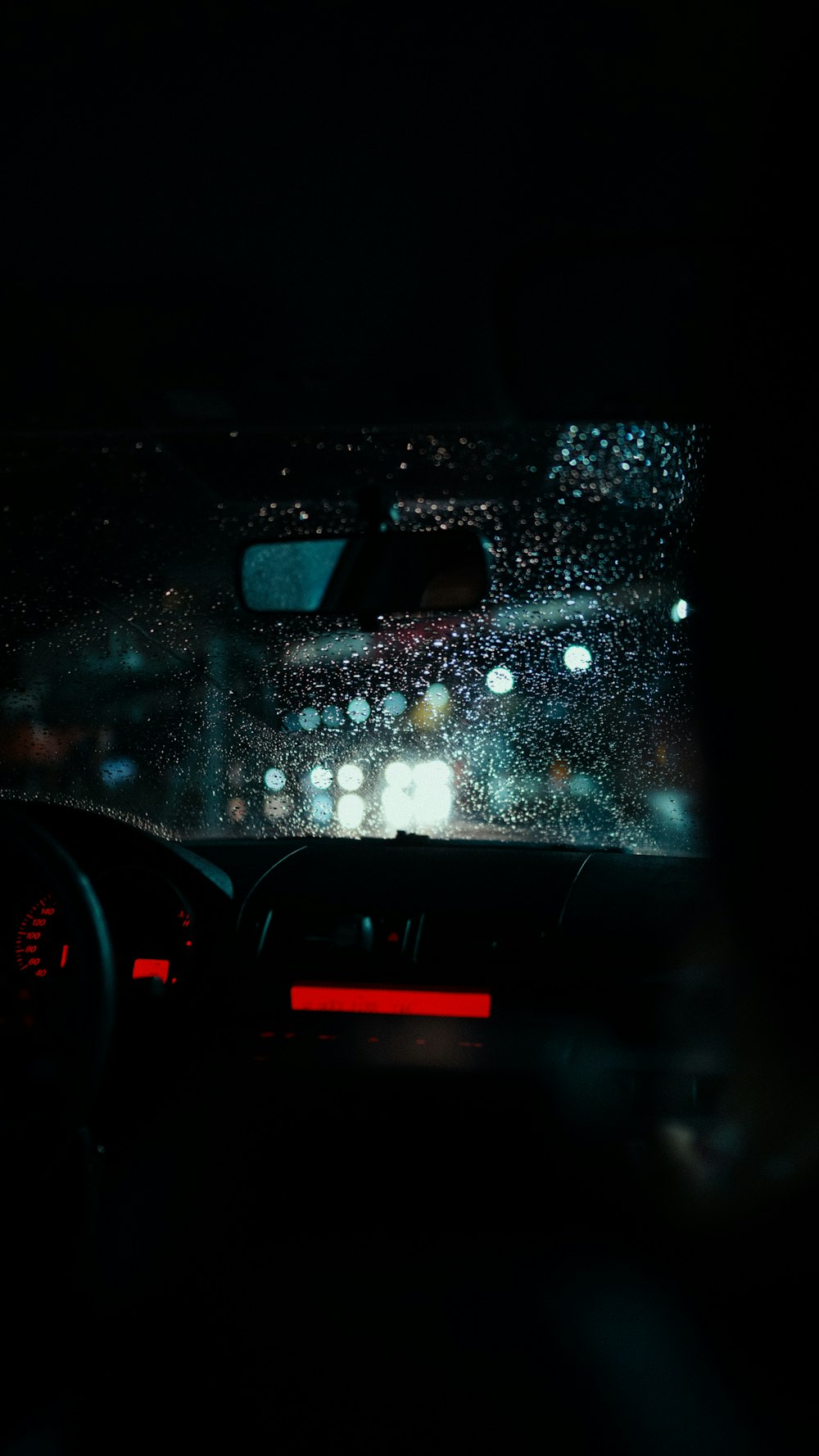 a car dashboard with rain on the windshield