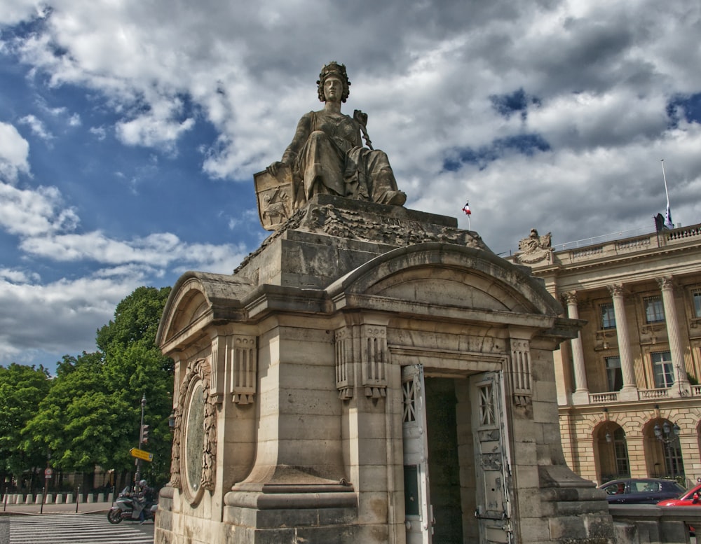 a statue of a man sitting on top of a building