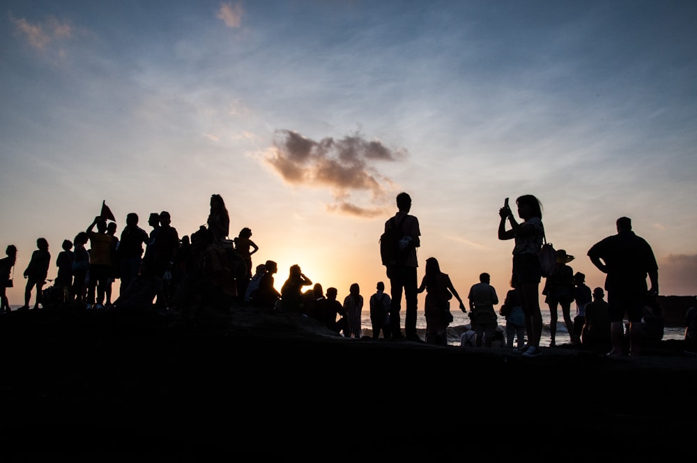 a group of people standing on top of a beach